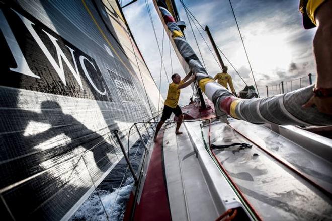 Onboard Abu Dhabi Ocean Racing – Justin Slattery and his shadow pull down the furled FRO as the team heads deeper into the Atlantic Ocean - Leg six to Newport – Volvo Ocean Race 2015 © Matt Knighton/Abu Dhabi Ocean Racing